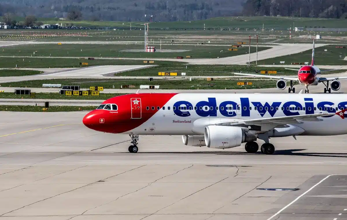 Pista aeroportuale avvolta da cenere vulcanica con aereo fermo sullo sfondo