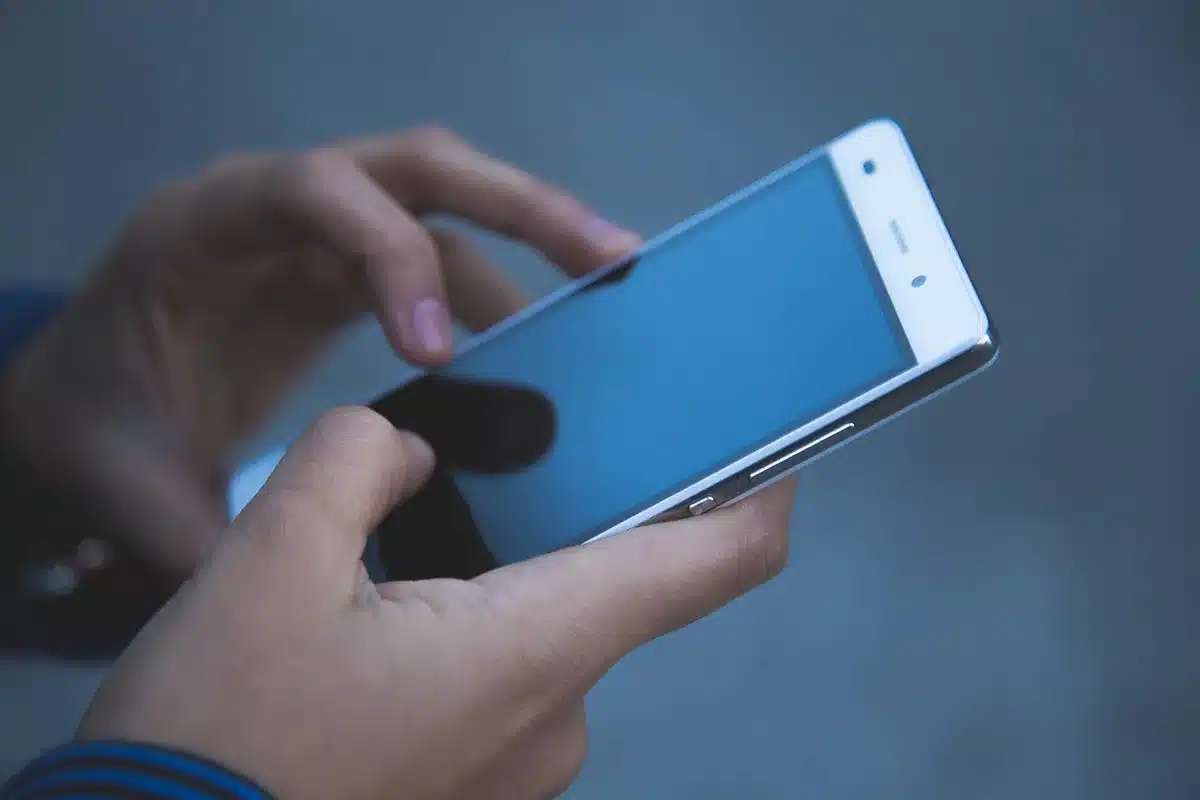 Due persone che si guardano con incertezza, con telefono in mezzo, simbolo di distanza emotiva.
