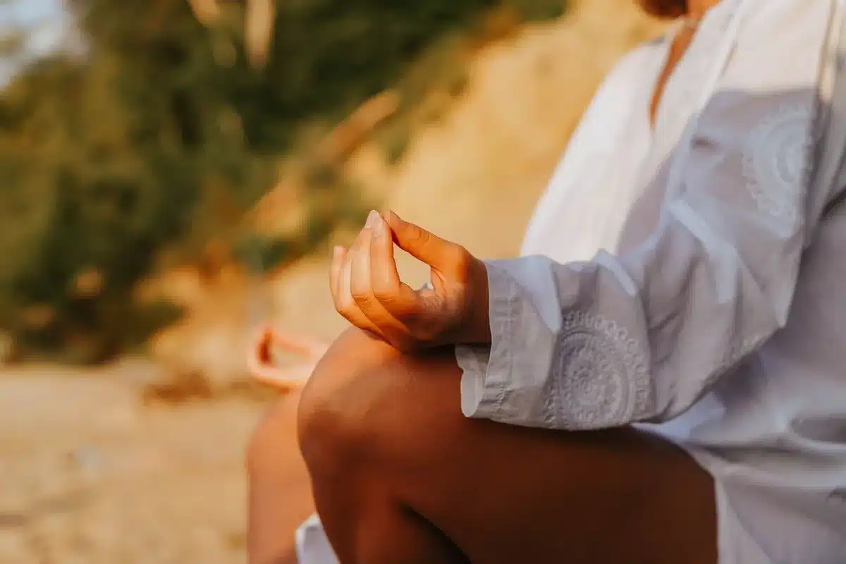 Persona in posizione meditativa con focus sul respiro e sul rilassamento consapevole