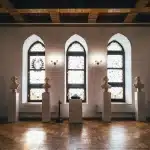 Interno di museo con opere d'arte esposte e visitatori che osservano le mostre