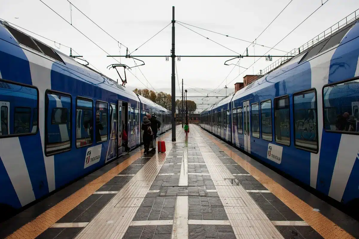 Passeggeri in attesa su un binario ferroviario durante l'attivazione di convogli straordinari