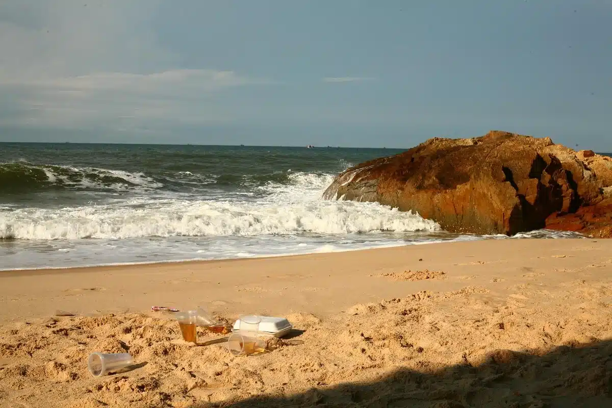 Spiaggia della Sardegna con teli verdi che coprono rifiuti emersi dall'erosione costiera