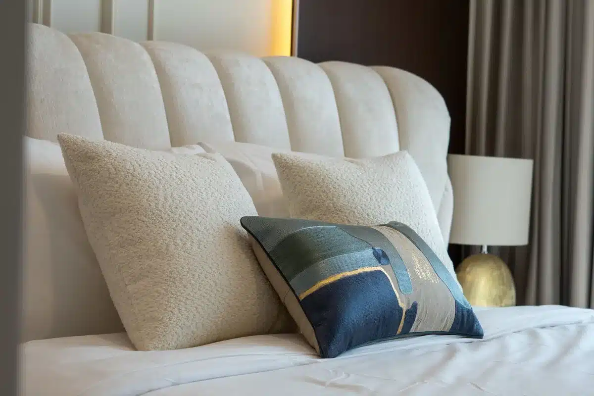 Letto confortevole con cuscini e biancheria ordinata in luce naturale mattutina