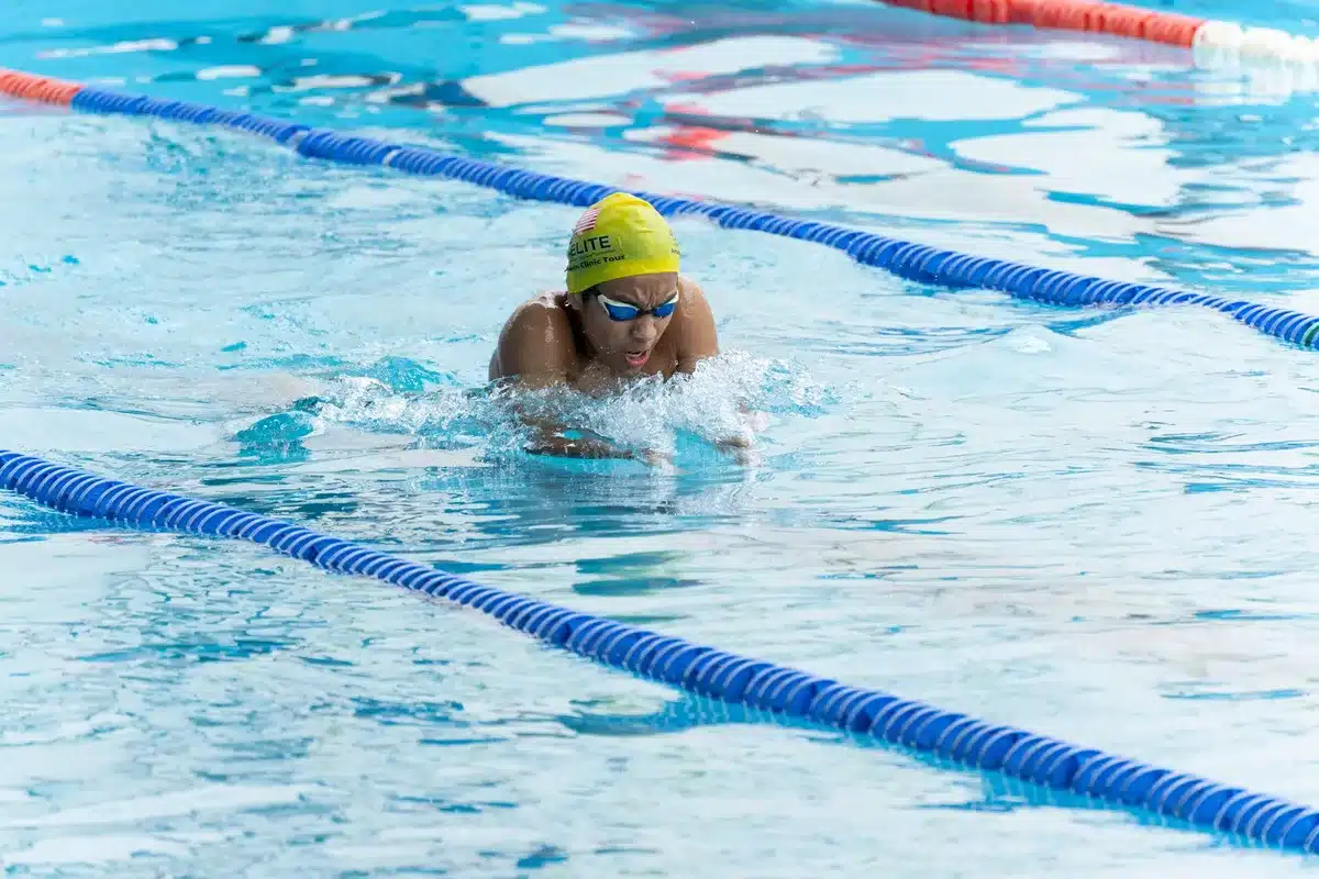 Nuotatrice in azione durante una gara di dorso in piscina olimpionica