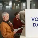 Persone anonime che votano in un seggio elettorale britannico il giorno delle elezioni