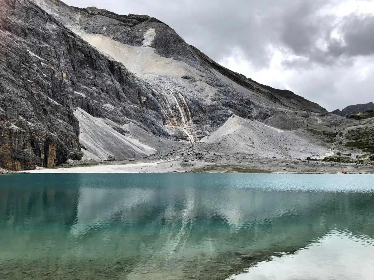 Pianoforte in un paesaggio alpino con lago e montagne sullo sfondo