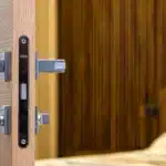 Mani che controllano una serratura di porta e verificano il funzionamento prima di partire