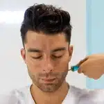 Persona che riceve un trattamento hydrafacial con applicatore professionale in ambiente clinico sereno