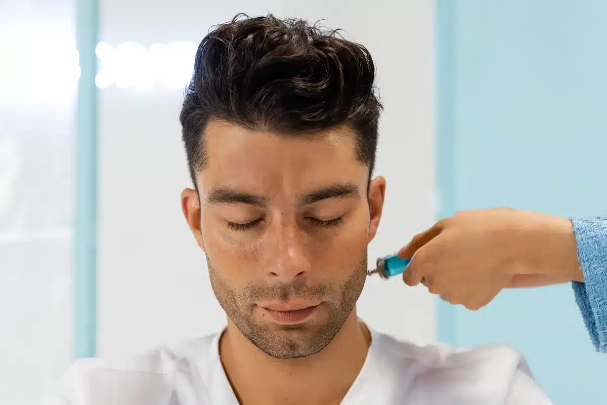 Persona che riceve un trattamento hydrafacial con applicatore professionale in ambiente clinico sereno