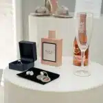 Flaconi di profumo eleganti e lussuosi disposti su una superficie decorativa con illuminazione natalizia