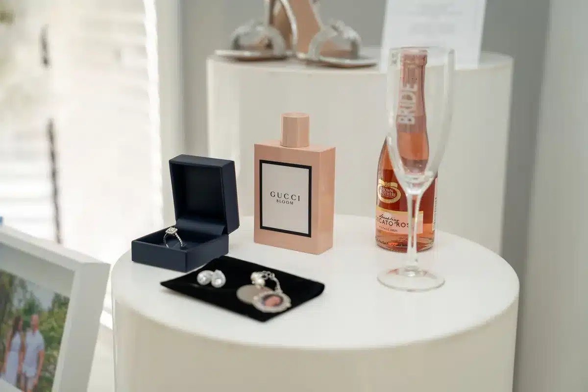 Flaconi di profumo eleganti e lussuosi disposti su una superficie decorativa con illuminazione natalizia