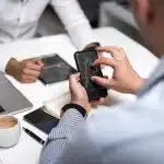 Scrivania di redazione con analitiche su schermo, dispositivi mobili e appunti di ricerca