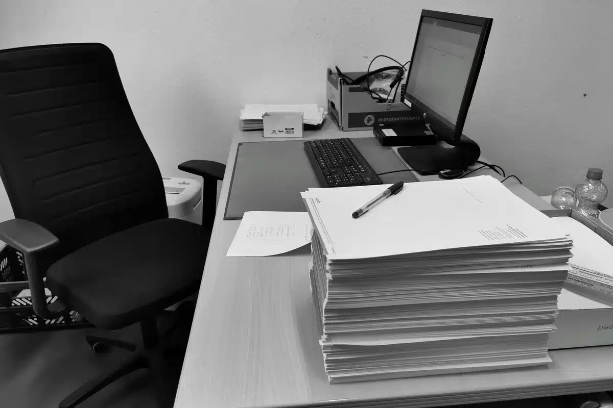 Documenti burocratici accumulati su una scrivania di ufficio