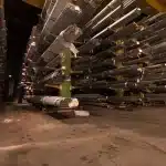 Persone discutono di piani logistici in un magazzino moderno con attrezzature industriali sullo sfondo