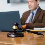 Martello di un giudice su documenti legali in aula di tribunale, simbolo di giustizia minorile