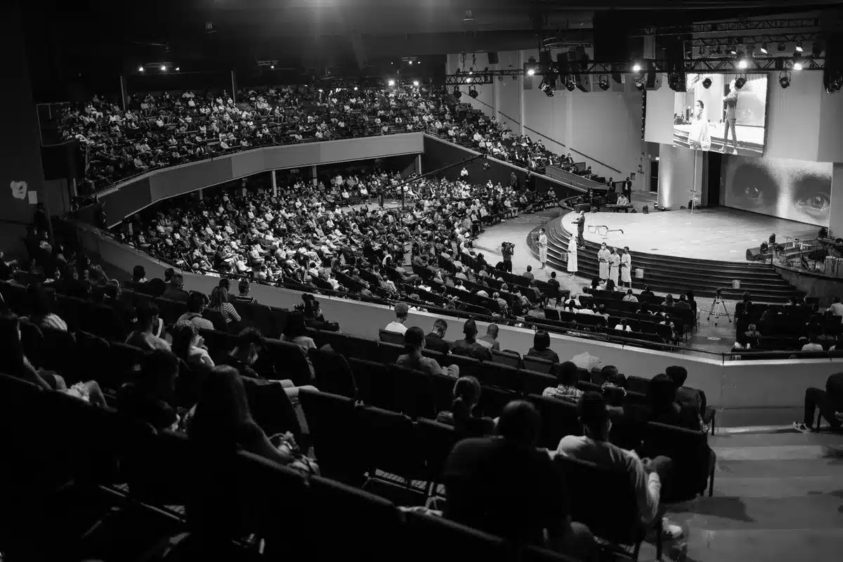 Pubblico seduto in teatro durante un incontro con autori sul palco illuminato