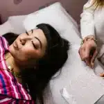 Tecnico di microblading applica pigmenti su sopracciglia durante una seduta di trattamento cosmetico