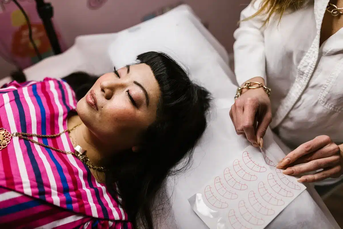 Tecnico di microblading applica pigmenti su sopracciglia durante una seduta di trattamento cosmetico