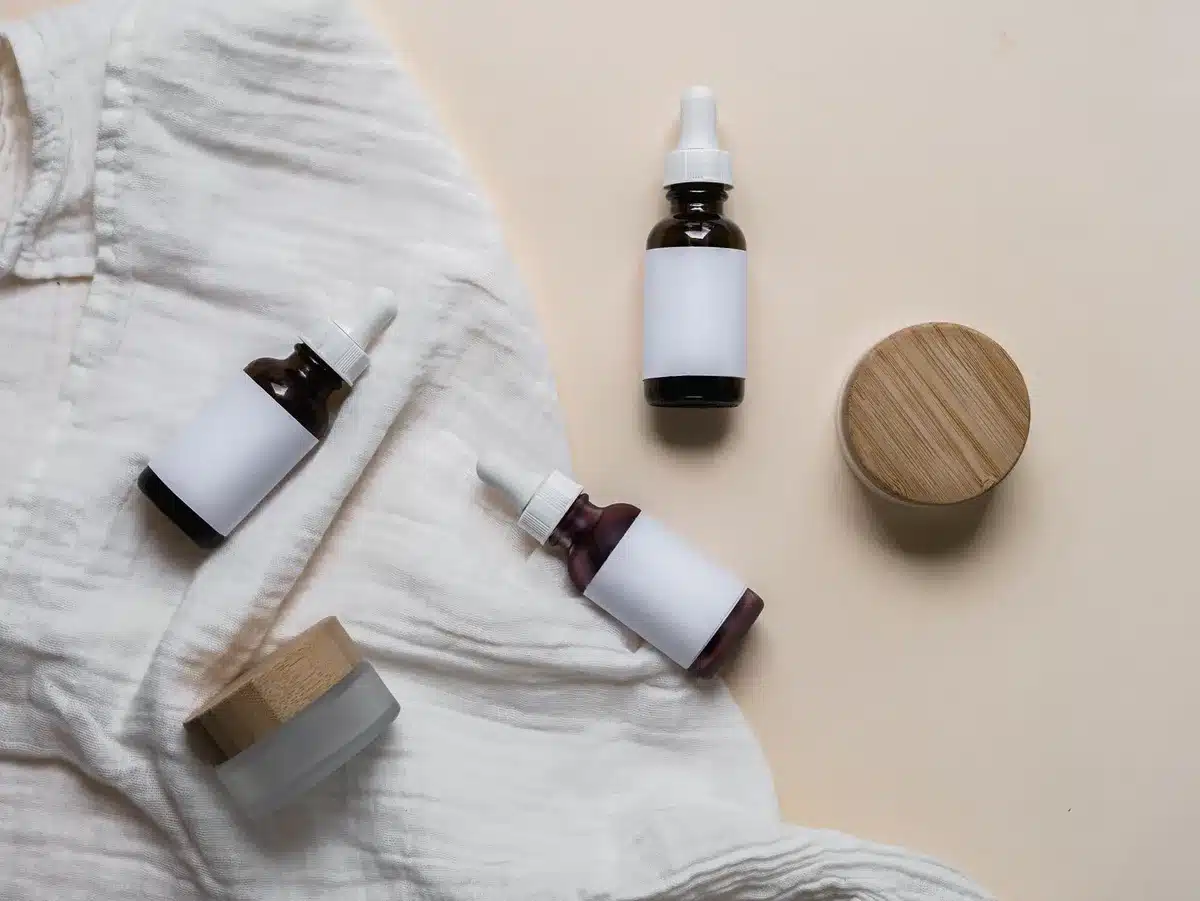 Bottiglie e contenitori di ingredienti skincare come acido ialuronico e ceramidi
