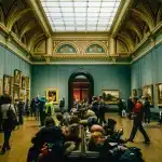 Visitatori in una galleria d'arte contemporanea con esposizioni multistrato di storia e cultura