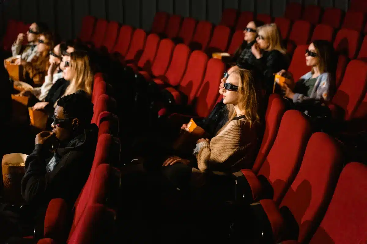 Spettatori seduti in una sala cinematografica durante la proiezione di un film