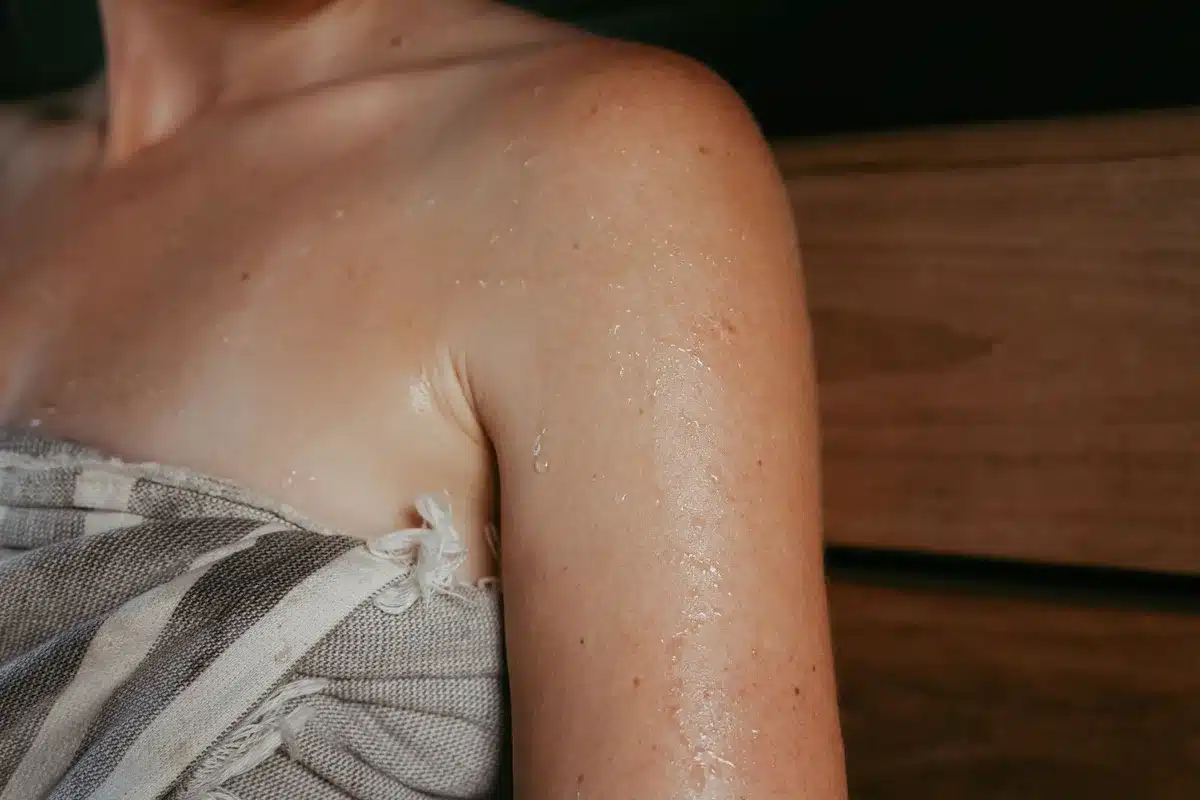 Donna che applica spray rinfrescante sulla pelle durante una giornata calda