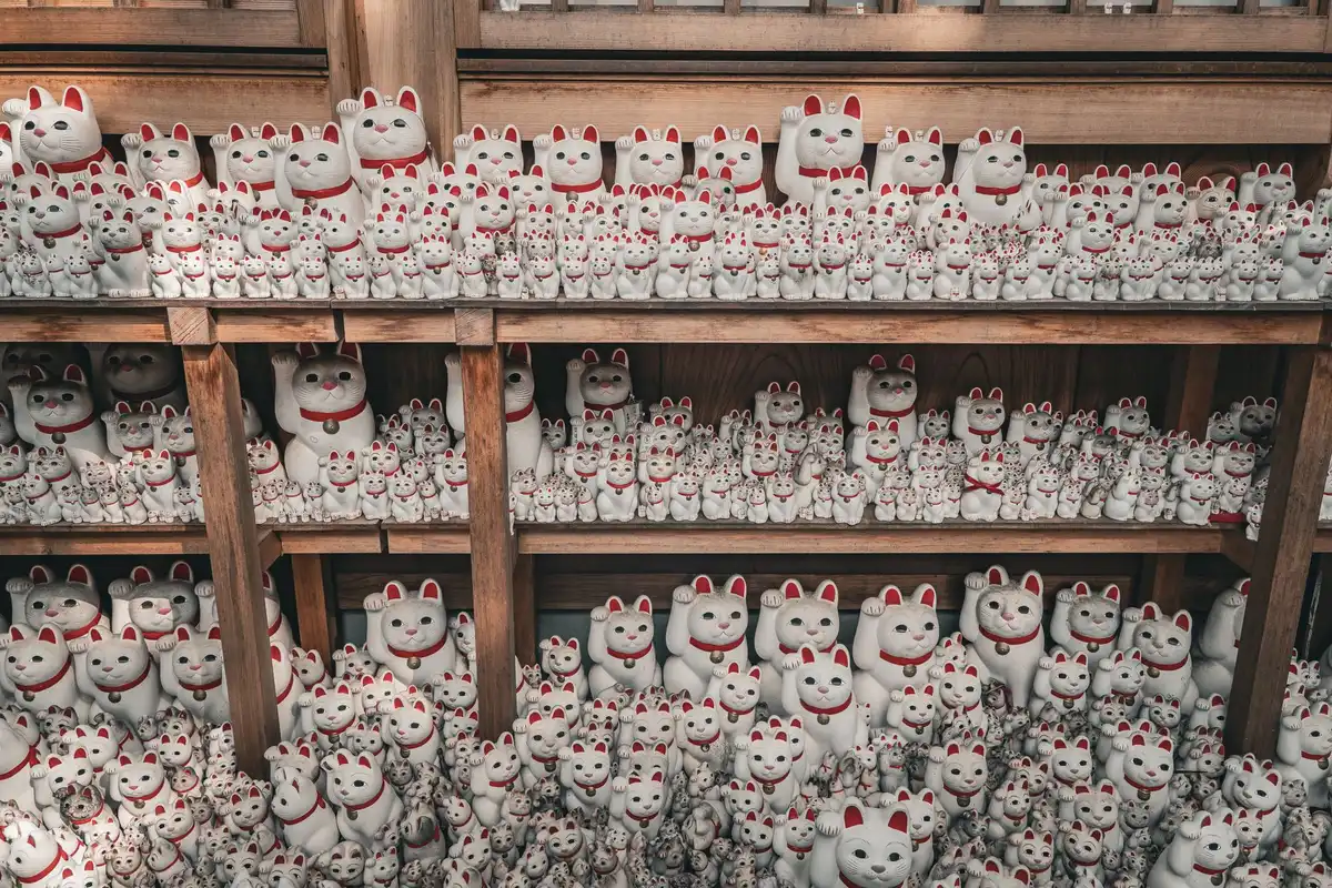 Dettaglio di statuette di gatti in ceramica, legno e vetro provenienti da diverse regioni