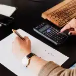Documenti di ristrutturazione e budget su tavolo di lavoro con calcolatrice e progetti