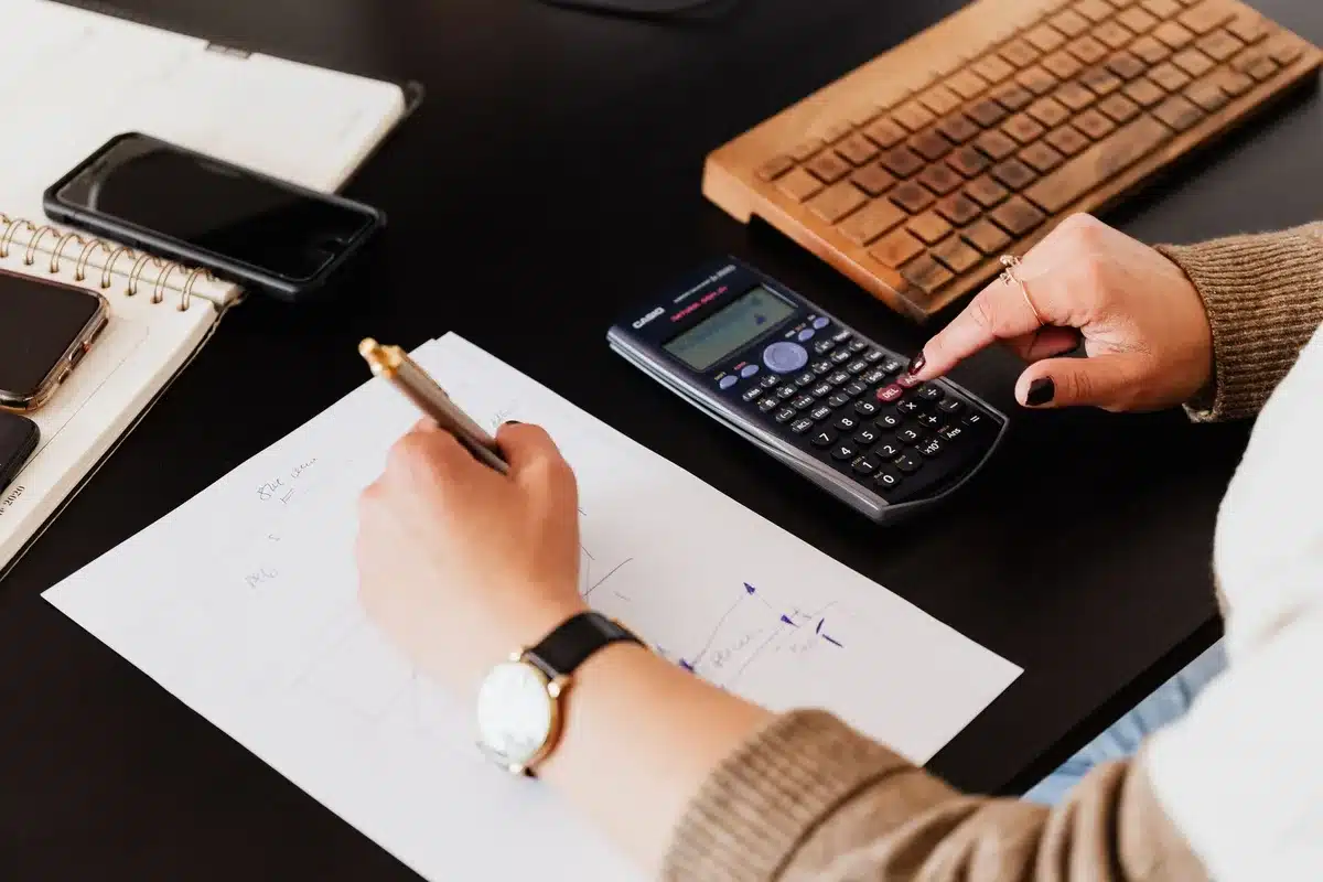 Documenti di ristrutturazione e budget su tavolo di lavoro con calcolatrice e progetti