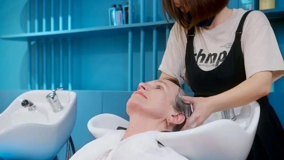 Persona che applica shampoo antiforfora sui capelli durante il lavaggio