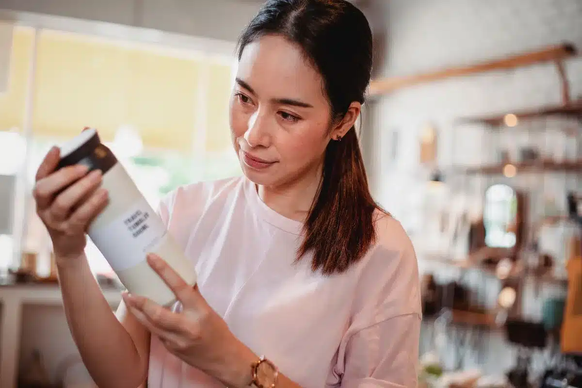 Consumatrice che legge attentamente l'etichetta degli ingredienti di un prodotto cosmetico