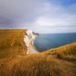 Scogliere bianche di gesso con strati geologici visibili che si tuffano nel mare
