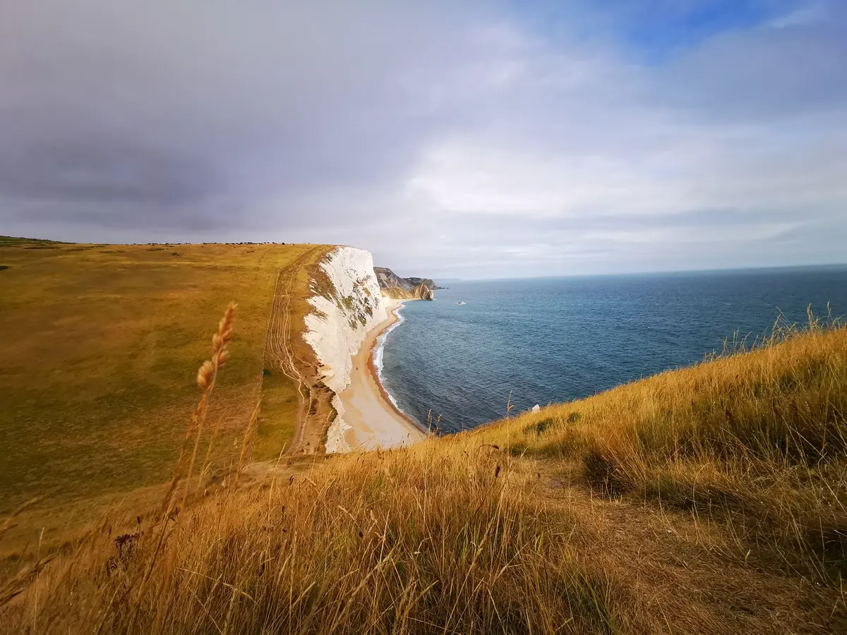 Scogliere bianche di gesso con strati geologici visibili che si tuffano nel mare