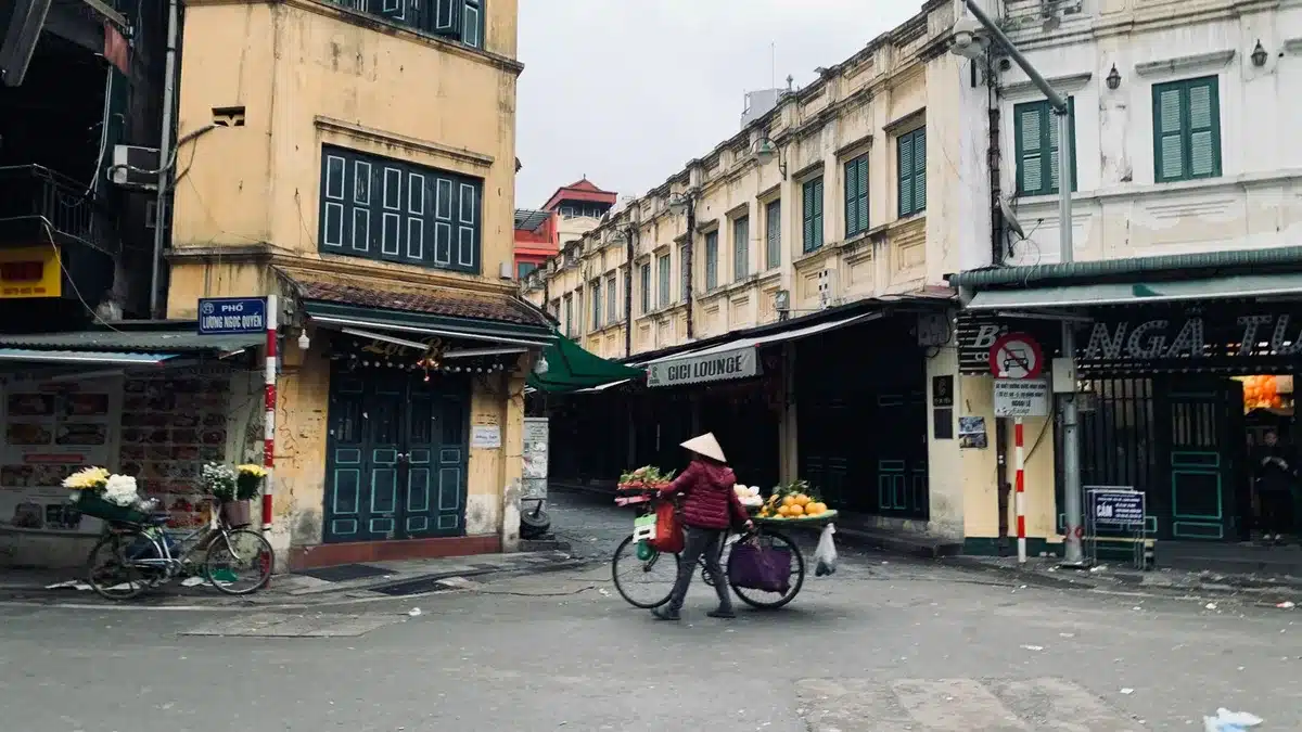 Viuzze affollate del centro storico di Hanoi con bancarelle di street food e scooter