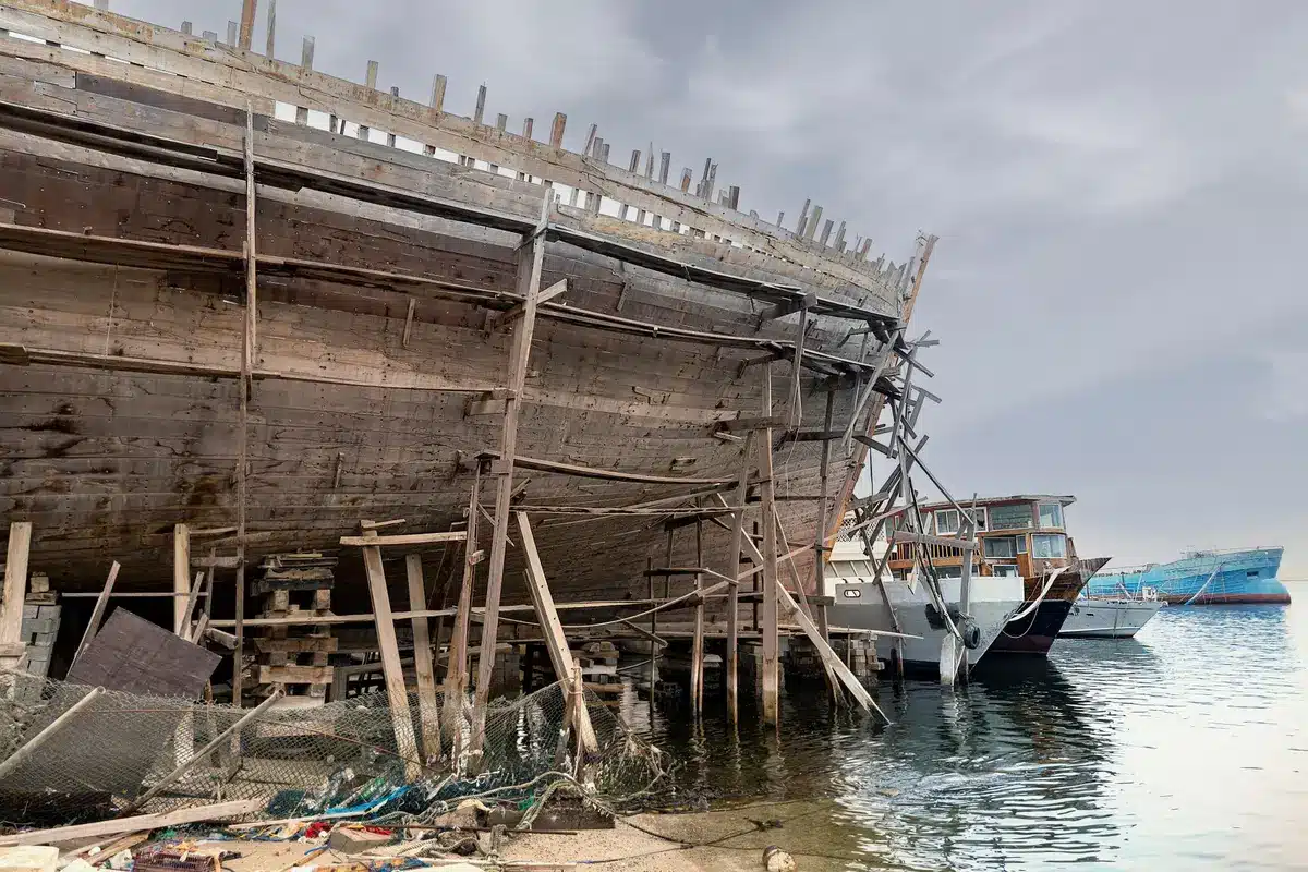 Cantiere navale con gru e scafi in costruzione durante difficoltà economiche