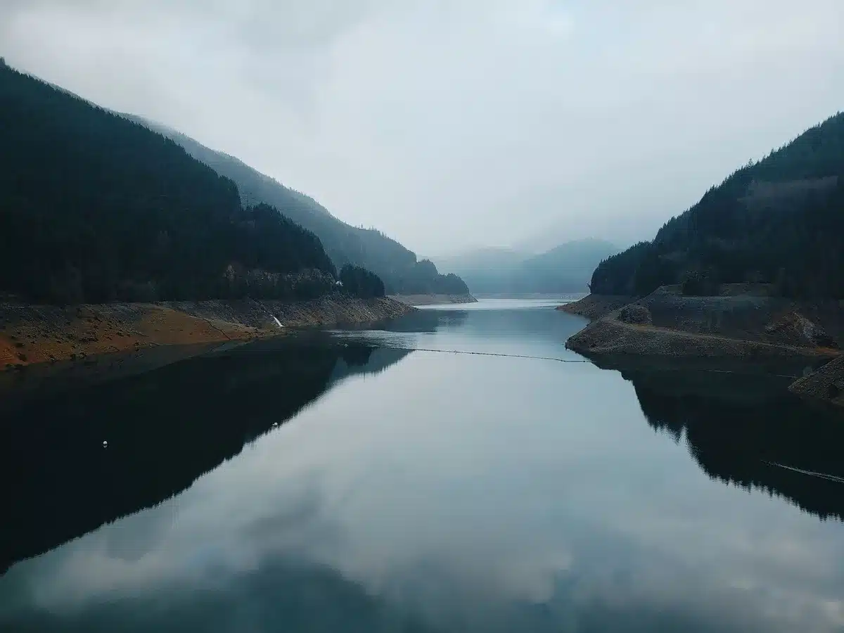 Paesaggio alpino simmetrico con montagne innevate riflesse in acque tranquille di un lago
