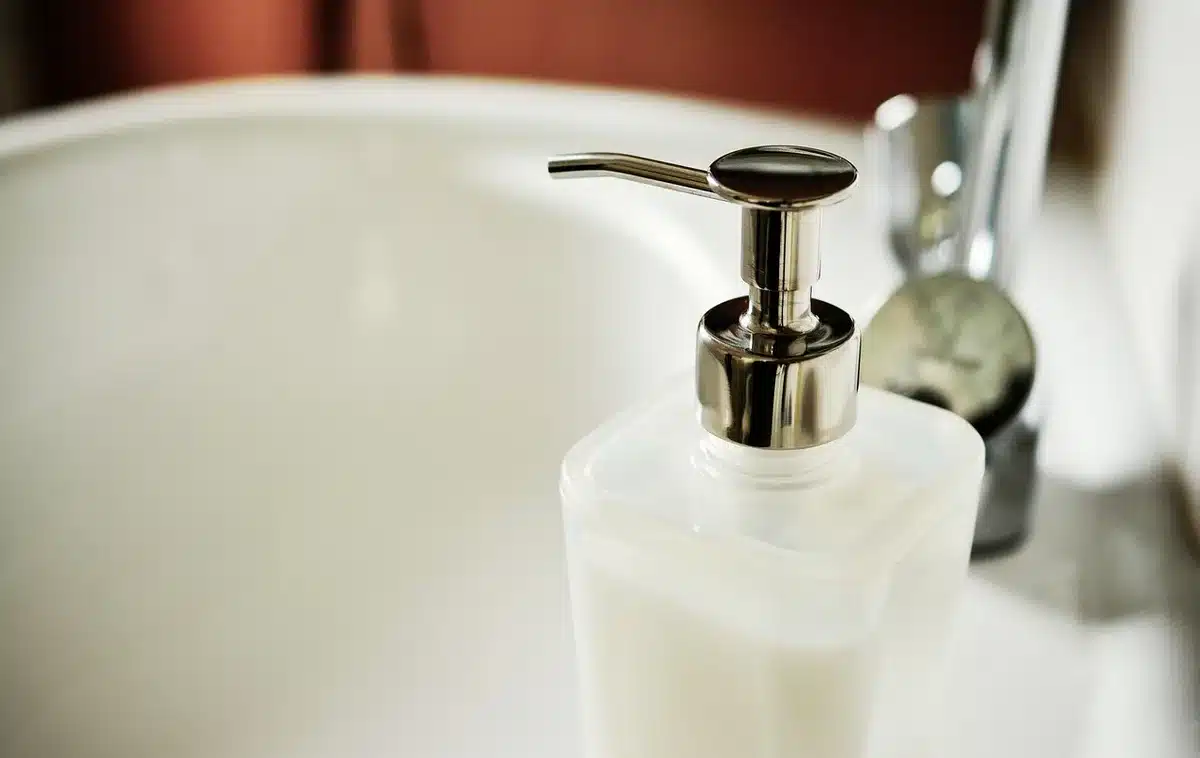 Bicarbonato di sodio e sapone nero in contenitori accanto a spugne e panni per le pulizie