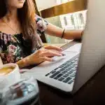 Scrivania editoriale con bozze di layout e laptop chiuso, simbolo di gestione annunci
