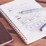 Documenti di pianificazione urbana e mappe tecniche su una scrivania con mani che esaminano i disegni