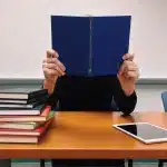 Studenti in aula che consultano diari e quaderni sul banco