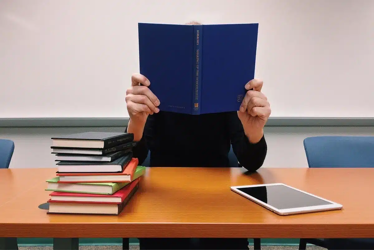 Studenti in aula che consultano diari e quaderni sul banco
