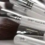 Flaconi di profumo e prodotti di bellezza di lusso su superficie elegante con illuminazione soft