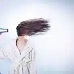 Mani che aggiustano un cerchietto a zigzag su capelli ondulati con luce naturale