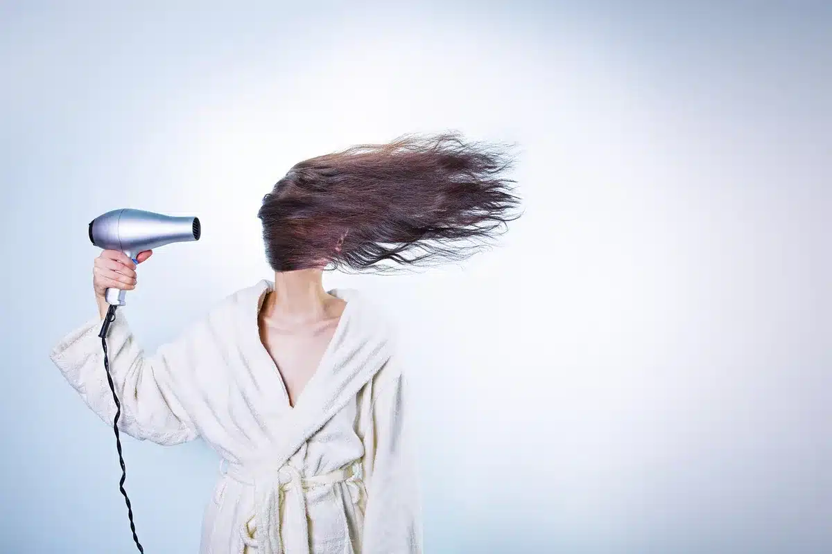 Mani che aggiustano un cerchietto a zigzag su capelli ondulati con luce naturale
