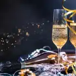Bicchieri di vino spumante e cocktail tintinnano in un cortile storico al tramonto durante una degustazione serale