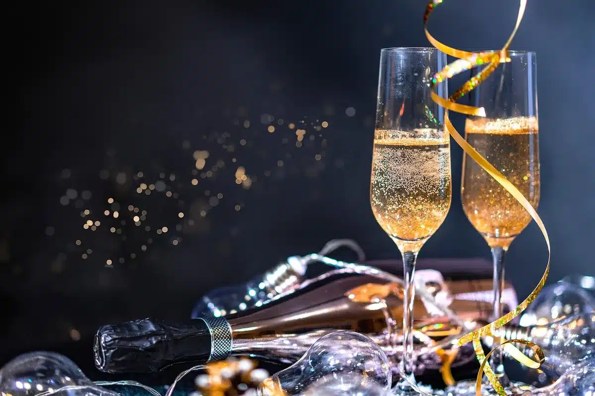 Bicchieri di vino spumante e cocktail tintinnano in un cortile storico al tramonto durante una degustazione serale