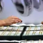 Anelli in argento e oro rosa con pietre preziose esposti con cartellini di sconto