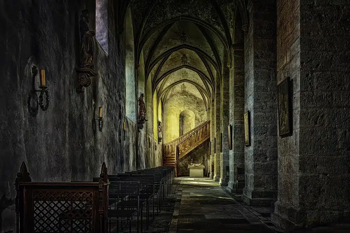 Libro aperto su tavolo in chiostro antico con luce naturale autunnale