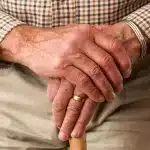 Mani che intrecciano capelli lunghi in una treccia elegante, con luce naturale