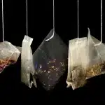 Mani anonime che tengono sacchetti di shopping colorati in un negozio al dettaglio illuminato
